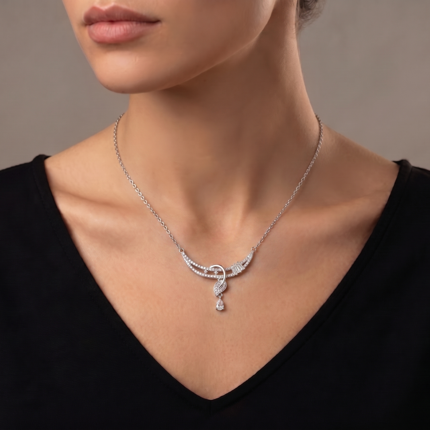 A flowing curve of shimmering crystals paired with a delicate heart drop, this necklace captures an elegant sparkle that feels graceful from every angle. The soft cascading design adds a refined charm that beautifully balances romance and modern luxury.