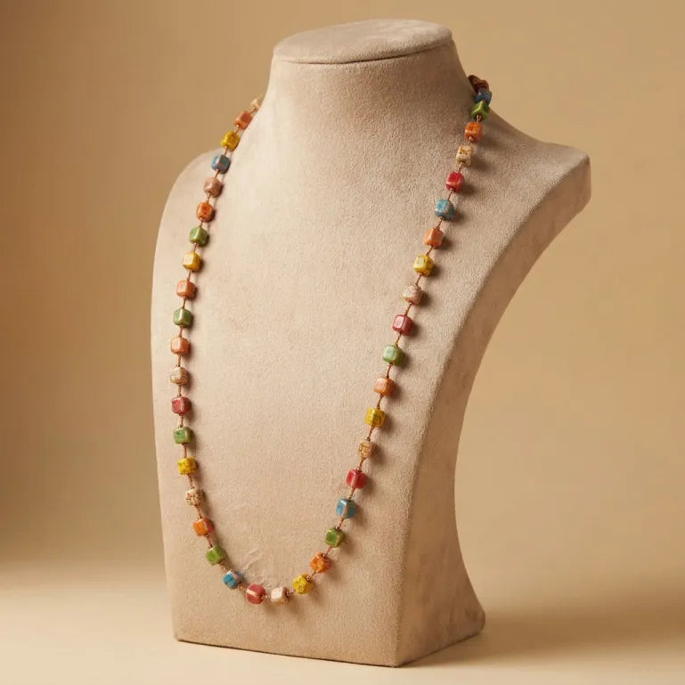 A playful trail of colors wrapped in boho charm, this necklace captures the joy of tiny candy-like beads arranged in a cheerful handmade style. With its colorful cube bead details and relaxed long silhouette, it brings a fun, artsy, and effortlessly expressive touch to any look.