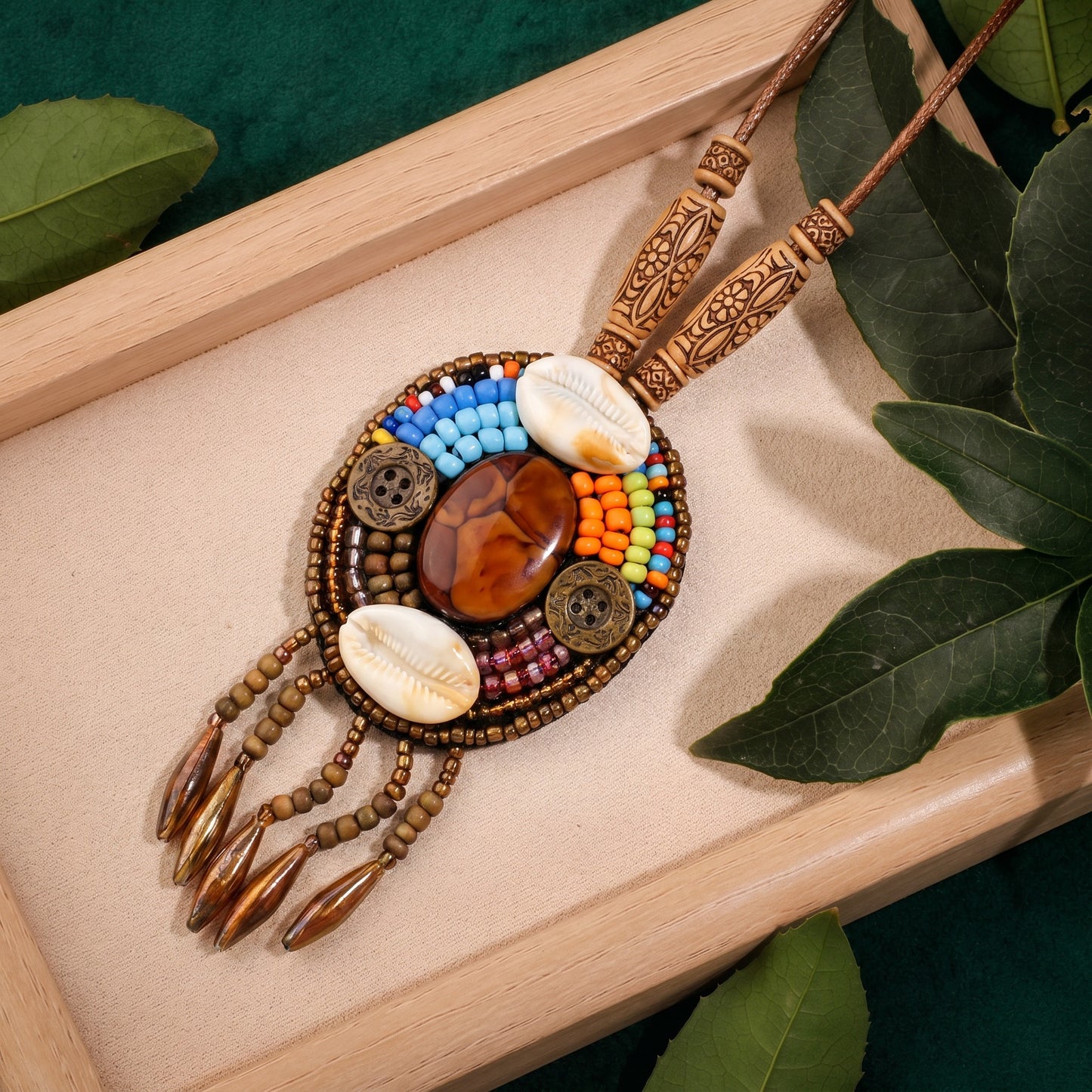 Inspired by wandering trails, sun-warmed earth, and timeless artisan craftsmanship, this necklace blends natural textures with intricate beadwork to create a statement rich in character. Its tribal-inspired details, shells, and earthy centerpiece evoke the spirit of distant journeys and free-spirited elegance.