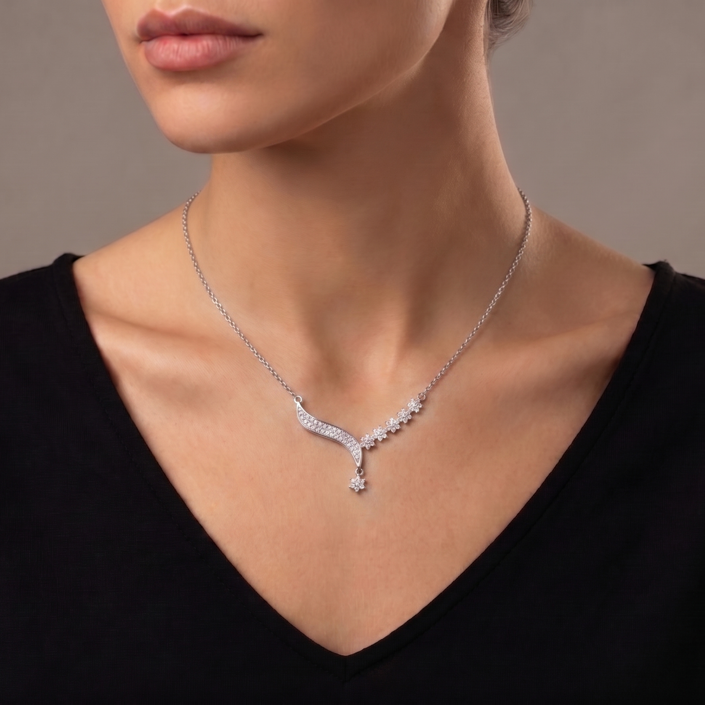 A delicate trail of shimmering florals and flowing crystal curves, this necklace captures a soft graceful sparkle that feels effortlessly elegant. Its asymmetrical design adds a modern romantic charm while keeping the look refined and timeless.
