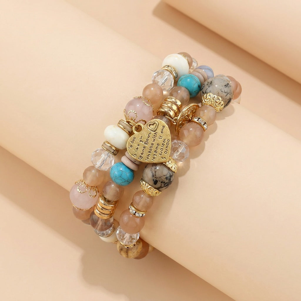A delicate blend of dreamy pastels and golden accents, this layered bracelet captures a soft romantic charm through its heart centerpiece, crystal beads, and earthy stone textures. Its graceful boho styling feels elegant, playful, and effortlessly feminine.