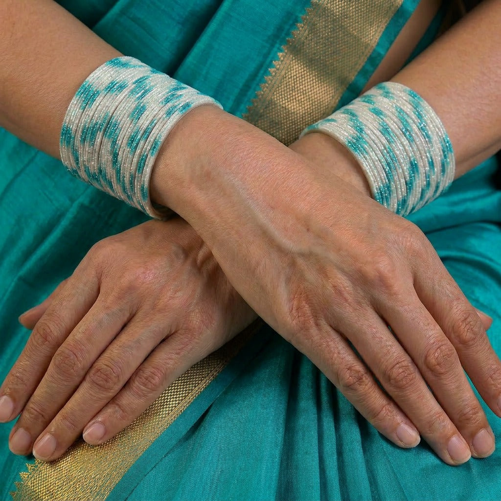 A radiant blend of tradition and celebration, these bangles glow in a vibrant pink hue adorned with delicate golden accents that shimmer beautifully in the light. Their festive sparkle and graceful stacked look bring a joyful charm to every ethnic moment.