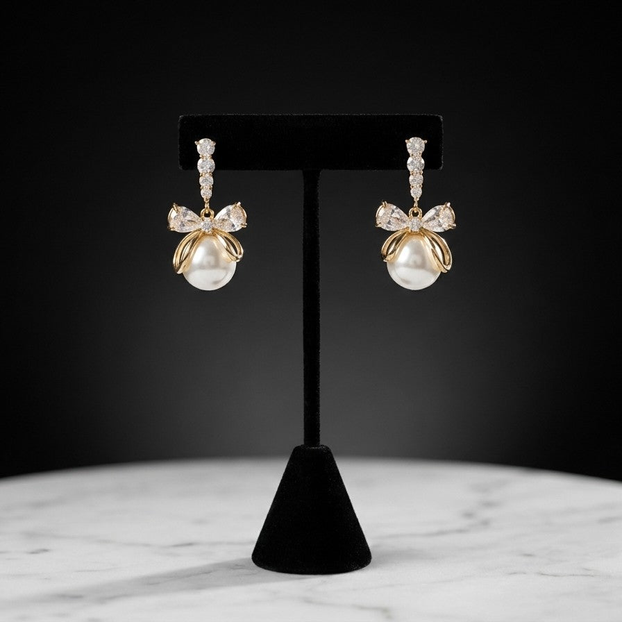 A soft cascade of pearls tied with elegance the Pearl Ribbon Drops blend delicate charm with graceful movement. Designed with a bow-inspired top and flowing pearl strands, these earrings create a romantic silhouette that feels light, feminine, and effortlessly refined. Each drop sways gently with every step, adding a subtle glow to both everyday looks and special moments