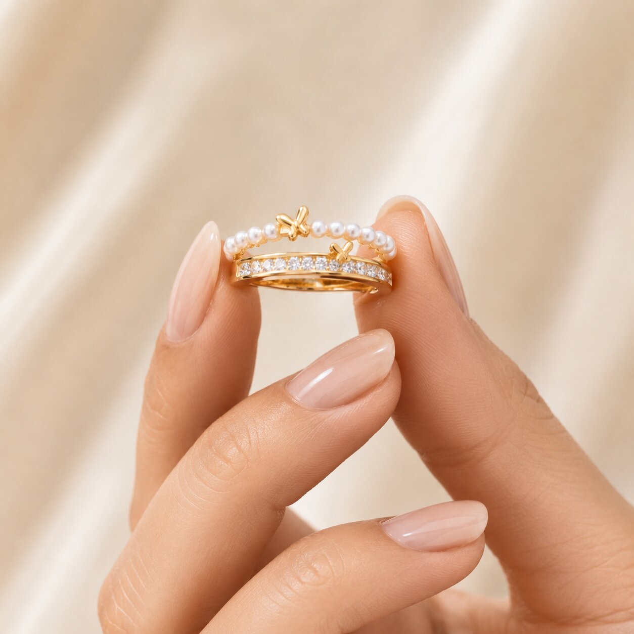 Like tiny butterflies dancing along a trail of glowing pearls, this elegant ring captures a graceful blend of softness, sparkle, and feminine charm. Featuring a delicate pearl-lined curve paired with shimmering crystal accents and golden butterfly motifs, it creates a refined statement that feels dreamy, enchanting, and effortlessly luxurious.