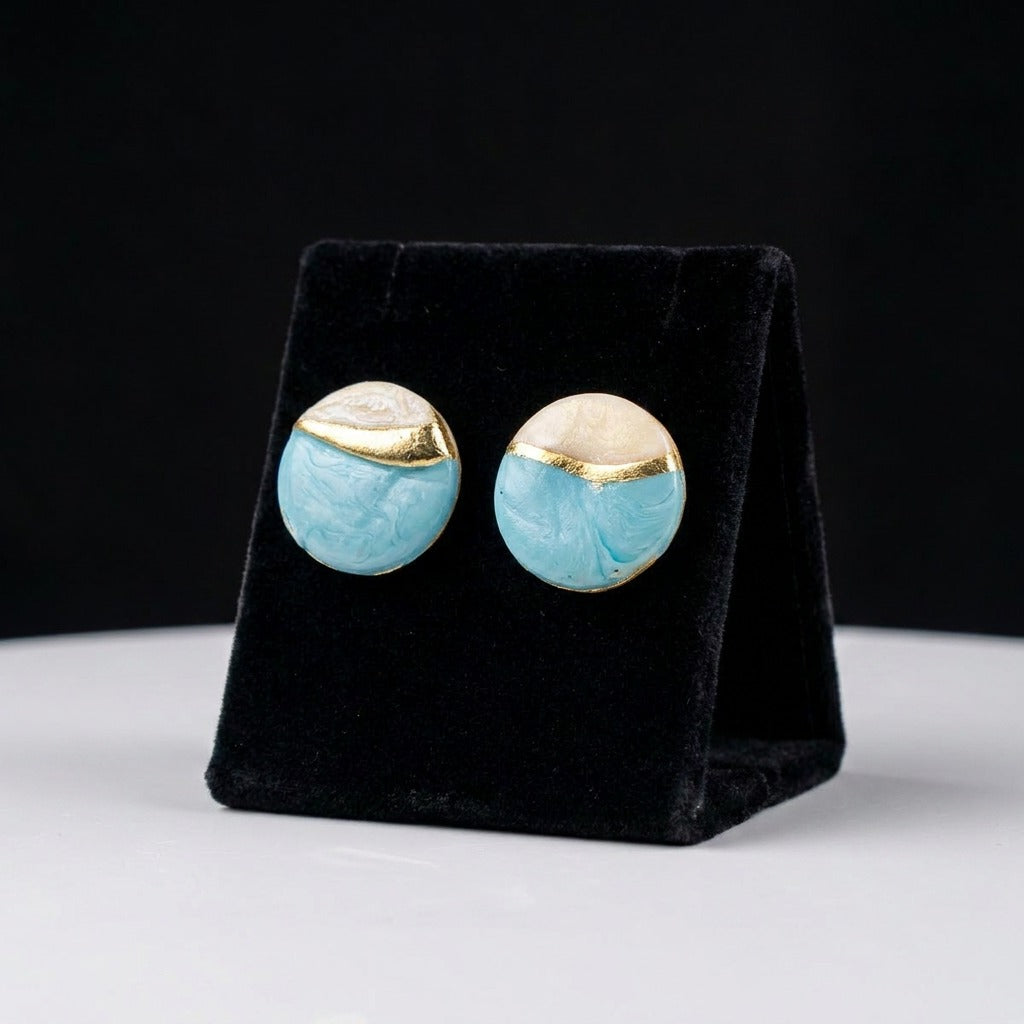 A serene blend of ocean hues and pearly elegance, these earrings feature soft aqua marbling paired with luminous ivory tones, divided by a graceful golden wave. Their dreamy palette captures the calm beauty of seafoam meeting the shore.