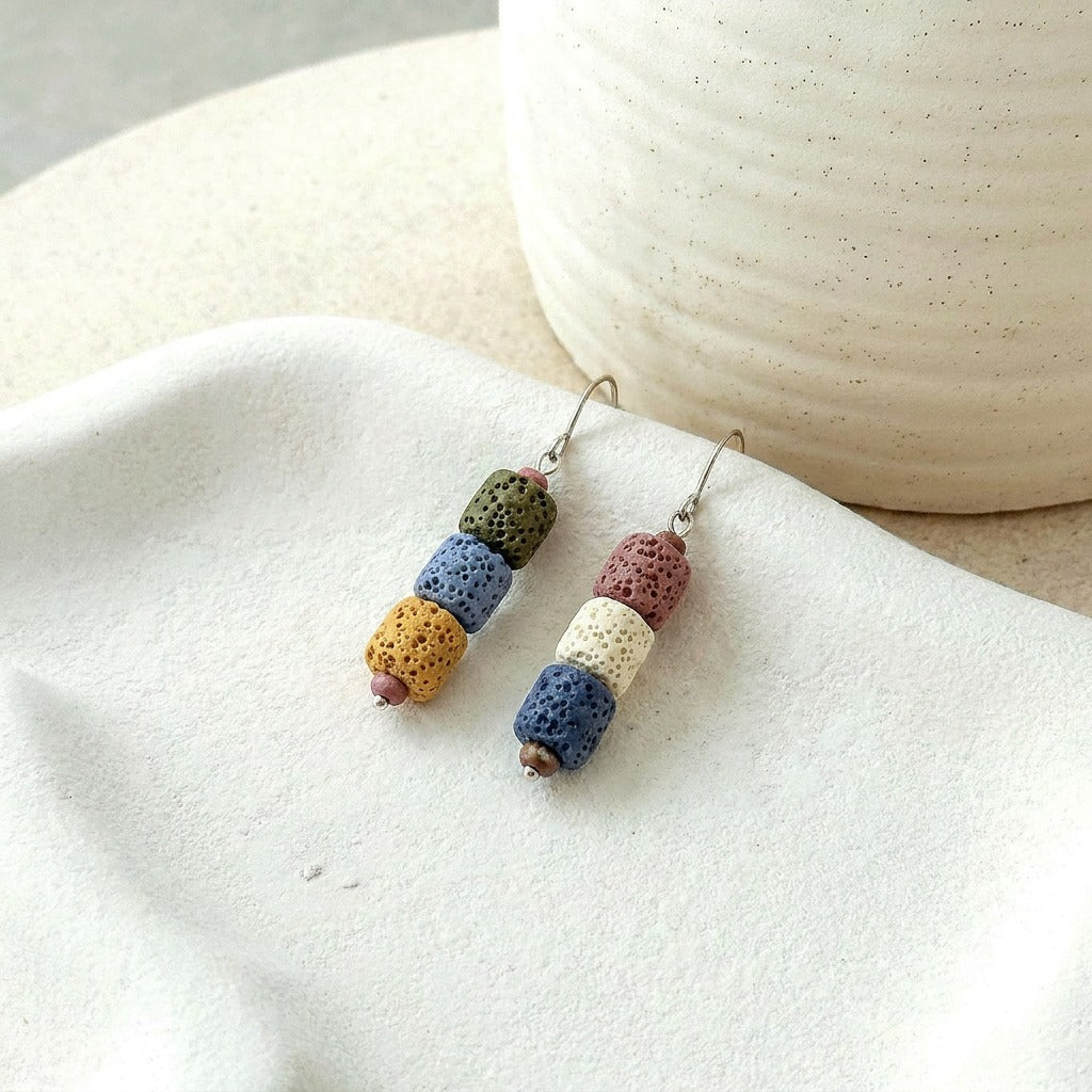 A playful blend of earthy textures and pastel tones, these earrings feature stacked ceramic-inspired beads with a handcrafted look that feels artistic, cozy, and effortlessly unique. Their soft color palette brings a charming boho touch to everyday styling.