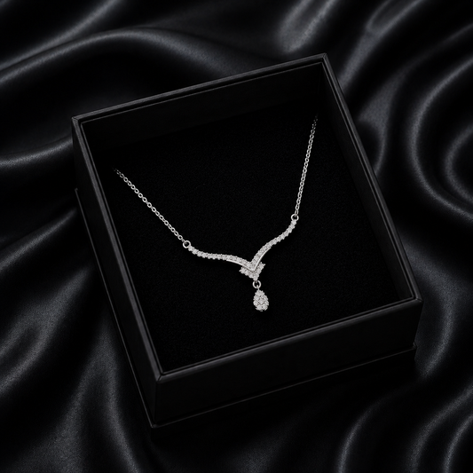 Inspired by the crisp, sparkling beauty of high-mountain peaks, the Alpine Drop Necklace is a masterclass in understated luxury. This piece features a graceful, V-shaped "Alpine" silhouette that leads the eye to a brilliant teardrop focal point, creating an elegant lengthening effect that elevates any neckline.