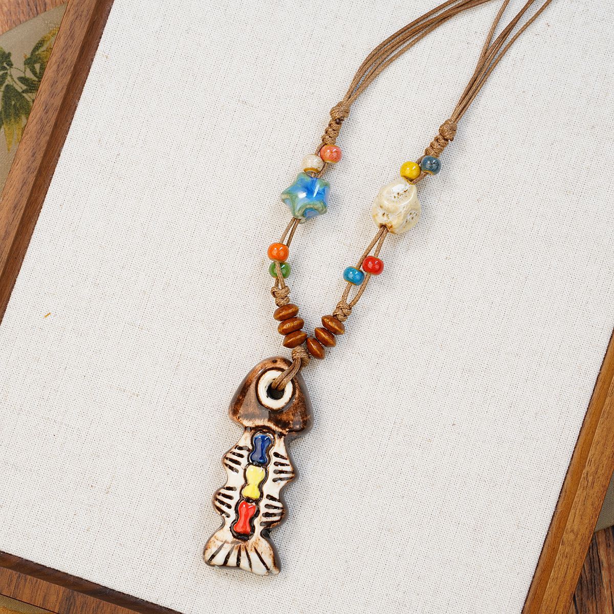A playful blend of color and craftsmanship, this handmade fish pendant carries tiny heart details that feel full of warmth and personality. With its artistic ceramic finish and soft earthy tones, it brings a whimsical, story-like charm to your everyday look.