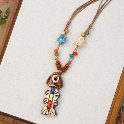 A playful blend of color and craftsmanship, this handmade fish pendant carries tiny heart details that feel full of warmth and personality. With its artistic ceramic finish and soft earthy tones, it brings a whimsical, story-like charm to your everyday look.