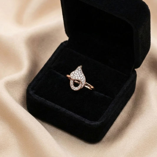 A romantic statement ring defined by a fluid heart-inspired silhouette and a soft cascade of shimmering zircon stones. The Amoria Flow Ring is designed to symbolize effortless love and graceful movement—where curves meet sparkle in perfect harmony. Elegant yet expressive, it adds warmth and charm to every gesture.
