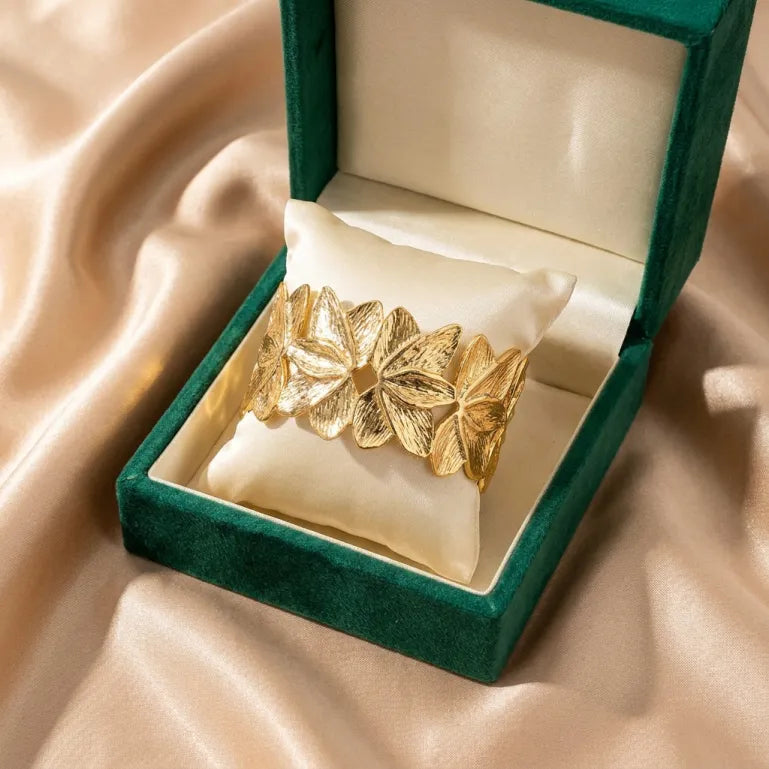 A celebration of blooming elegance, this cuff captures the beauty of golden petals layered in a graceful floral composition. With its sculpted flower-inspired design and radiant gold finish, it creates a bold yet sophisticated statement that feels artistic, luxurious, and effortlessly timeless.