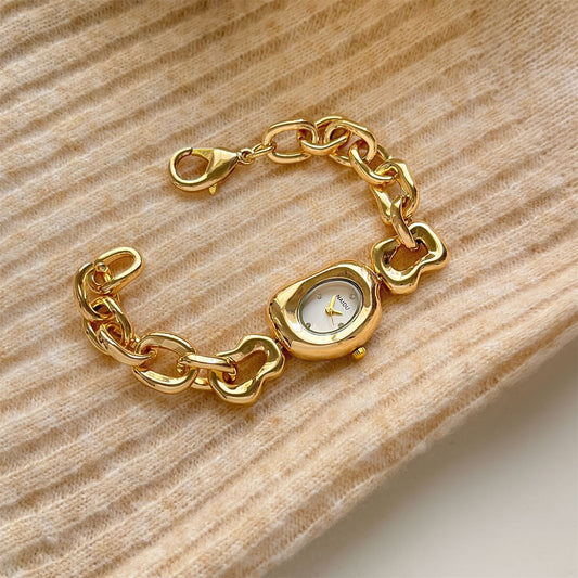 A fluid expression of elegance, where sculpted links flow seamlessly into a refined oval dial, creating a look that feels both modern and timeless. Designed to sit gracefully on the wrist, this piece blends soft femininity with a bold, polished presence.