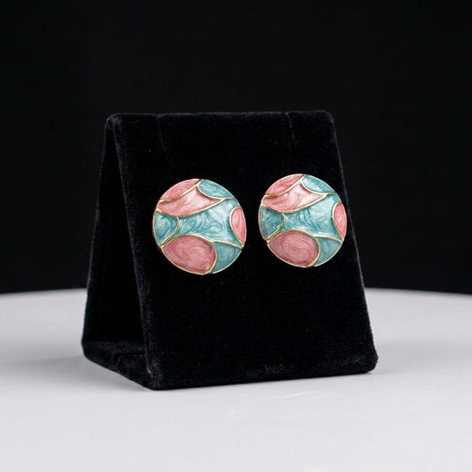 A dreamy fusion of blooming petals and ocean tides, these earrings showcase flowing blush pink and aqua enamel patterns that resemble watercolor waves meeting delicate florals. Their artistic palette creates a soft statement full of charm and elegance.