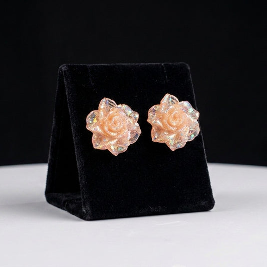A dreamy blend of soft blush tones and shimmering crystal glow, this floral piece captures the beauty of a blooming rose kissed with light. The translucent petals with iridescent sparkle create a delicate, almost magical look that feels both playful and elegant.