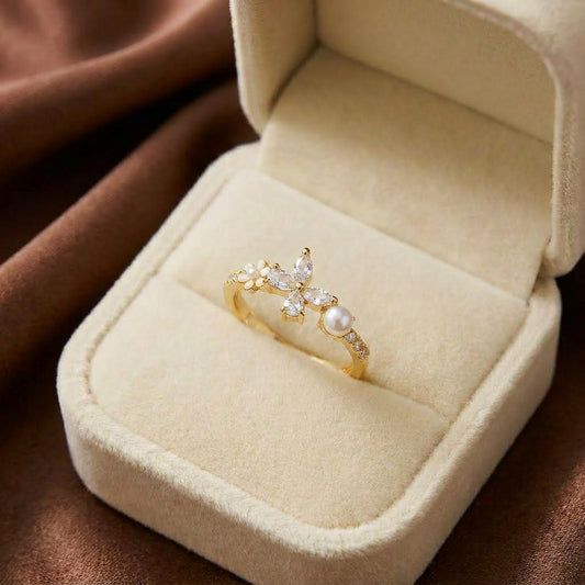 A graceful butterfly meets the timeless beauty of pearls in this delicate statement ring. Featuring sparkling crystal wings, a luminous pearl accent, and a tiny blooming flower detail, Butterpearl Ring captures the charm of a butterfly resting in a garden kissed by morning light.