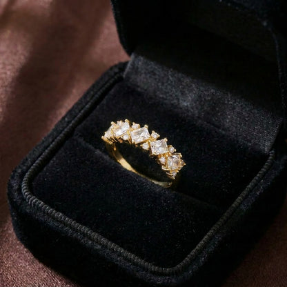 A graceful blend of royal elegance and delicate brilliance, this ring features a row of sparkling square-cut stones framed with intricate lace-like accents. Its refined silhouette creates a crown-inspired charm that feels luxurious, feminine, and timeless.