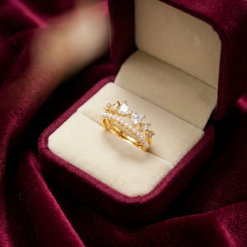 Like a tiny bow resting on a royal crown, this charming ring captures a playful blend of sweetness, elegance, and soft feminine sparkle. Featuring delicate bow-shaped crystal accents paired with a graceful pearl-lined curve, it creates a dreamy statement that feels cute, graceful, and effortlessly luxurious.