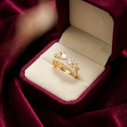 Like a tiny bow resting on a royal crown, this charming ring captures a playful blend of sweetness, elegance, and soft feminine sparkle. Featuring delicate bow-shaped crystal accents paired with a graceful pearl-lined curve, it creates a dreamy statement that feels cute, graceful, and effortlessly luxurious.