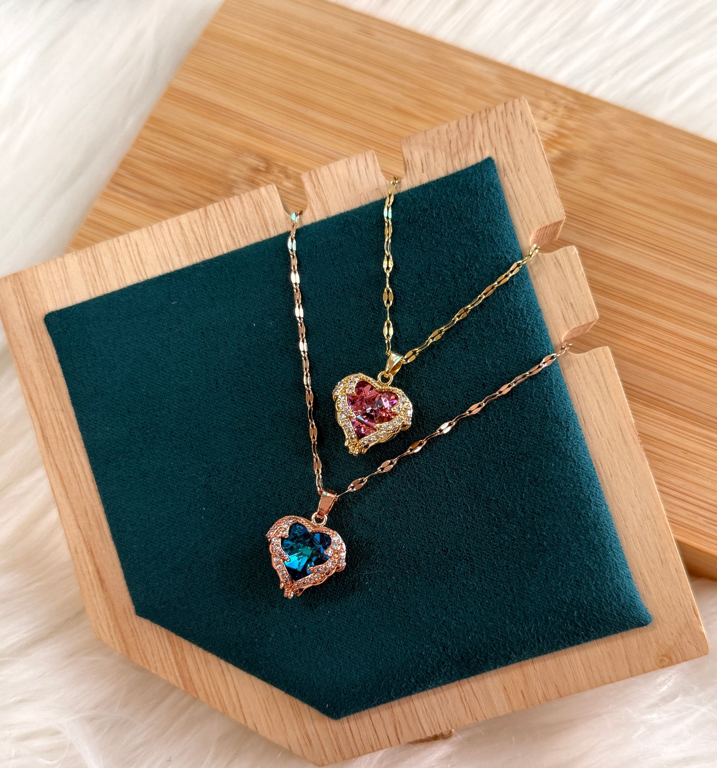 Heart-shaped jewelry set with gemstones on a wooden stand