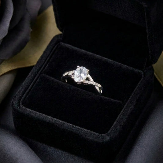 A soft radiance wrapped in timeless elegance, this ring captures the beauty of everlasting sparkle with its luminous oval centerpiece and gracefully flowing band. The delicate crystal accents create a refined silhouette that feels romantic, elegant, and effortlessly luxurious.