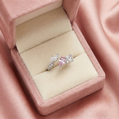 Like delicate vines curling around a soft blush bloom, this elegant ring captures a graceful blend of nature, sparkle, and feminine charm. Featuring a radiant pink heart-shaped crystal surrounded by leaf-inspired crystal accents, it creates a refined statement that feels romantic, enchanting, and effortlessly luxurious.