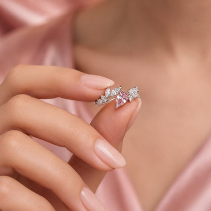 Like delicate vines curling around a soft blush bloom, this elegant ring captures a graceful blend of nature, sparkle, and feminine charm. Featuring a radiant pink heart-shaped crystal surrounded by leaf-inspired crystal accents, it creates a refined statement that feels romantic, enchanting, and effortlessly luxurious.