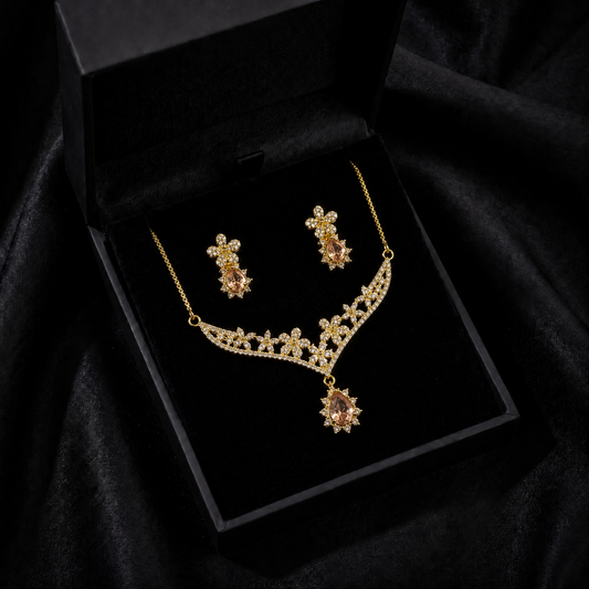 A delicate bloom of crystal flowers and warm champagne-toned stones, this set captures the elegance of a garden kissed by golden light. The floral vine silhouette paired with soft teardrop accents creates a graceful sparkle that feels romantic, refined, and timeless.