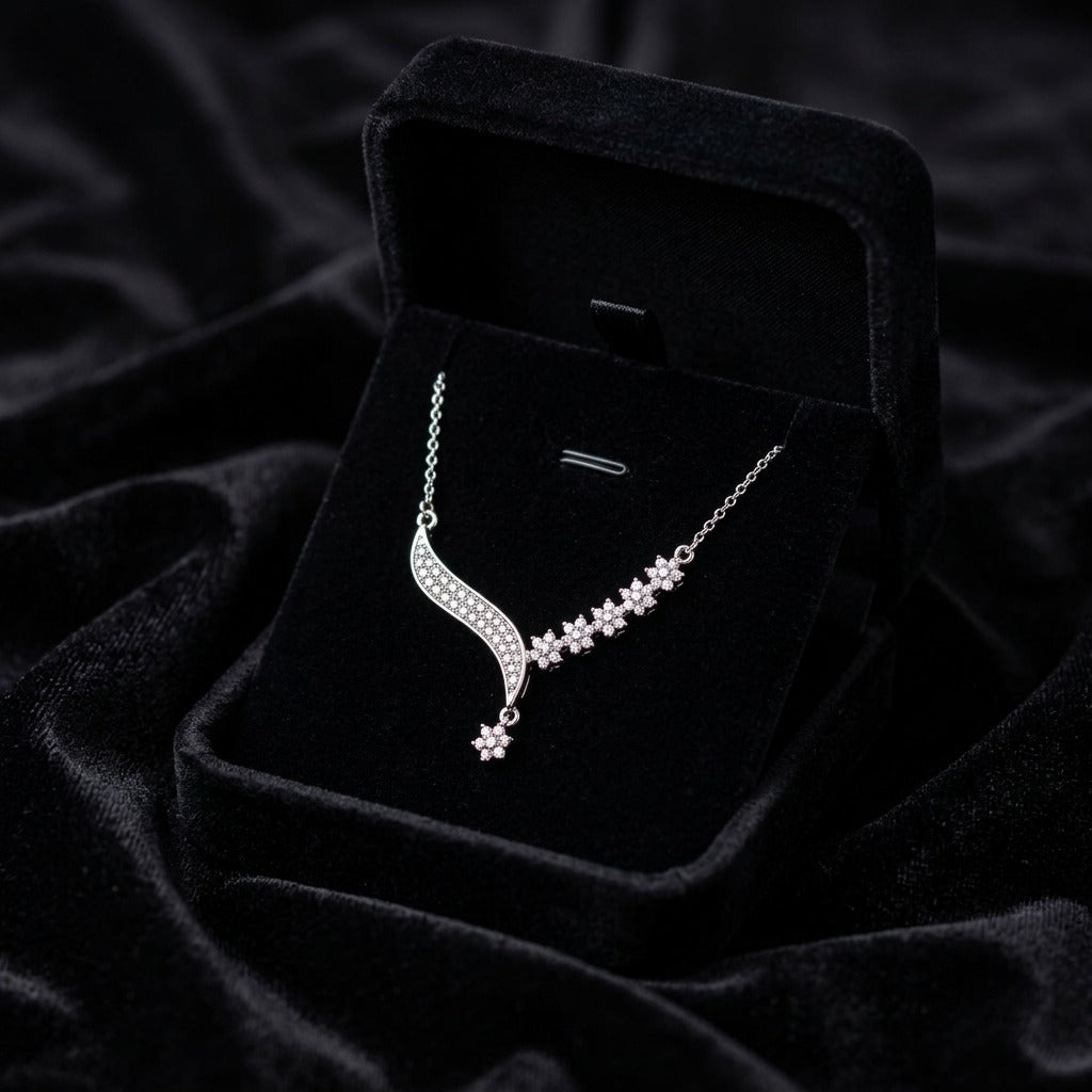 A delicate trail of shimmering florals and flowing crystal curves, this necklace captures a soft graceful sparkle that feels effortlessly elegant. Its asymmetrical design adds a modern romantic charm while keeping the look refined and timeless.