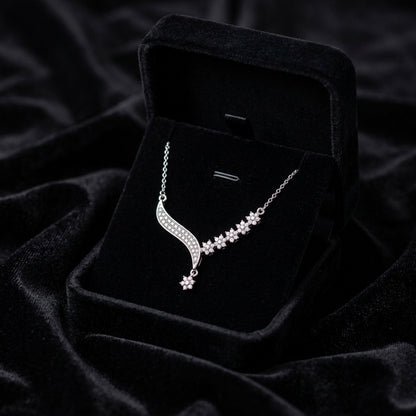 A delicate trail of shimmering florals and flowing crystal curves, this necklace captures a soft graceful sparkle that feels effortlessly elegant. Its asymmetrical design adds a modern romantic charm while keeping the look refined and timeless.