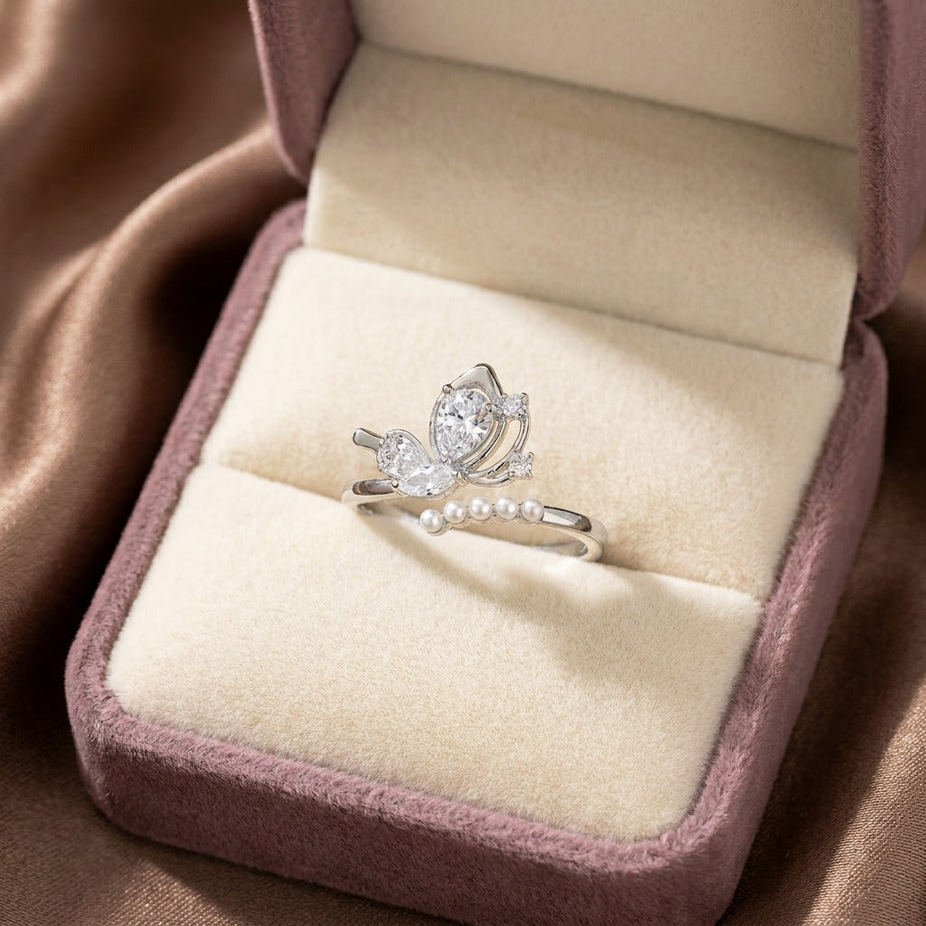 A delicate butterfly kissed with pearl elegance, this ring features a graceful wing-inspired centerpiece floating above a soft row of luminous pearls. Its dreamy crystal details and airy silhouette create a charming look that feels feminine, elegant, and beautifully whimsical.