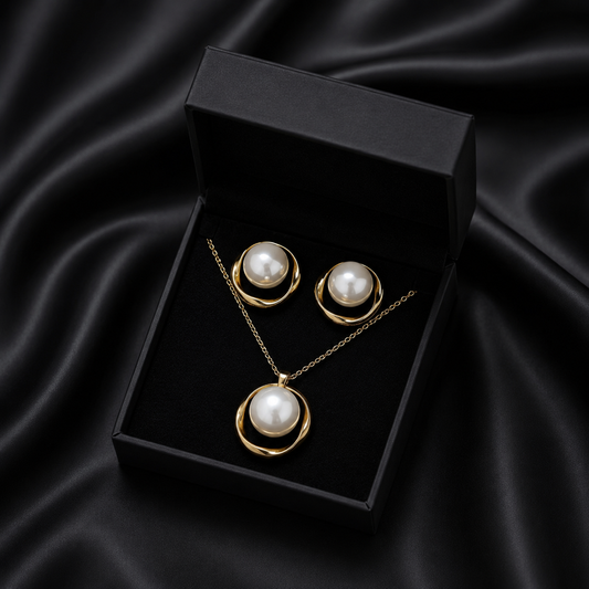 Capture the timeless beauty of the ocean’s treasures with the Gilded Ripple Set. This exquisite necklace and earring duo features a luminous, jumbo artificial pearl nestled within a flowing golden orbit, creating a look that is both bold and gracefully sophisticated.
