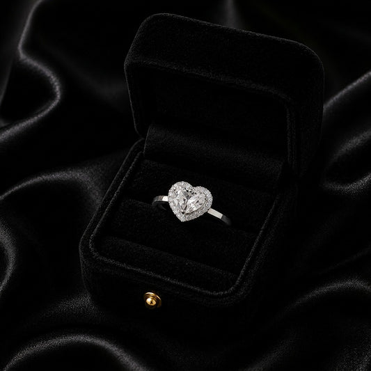 A symbol of love wrapped in radiant elegance, this ring features a sparkling heart-cut centerpiece embraced by a delicate halo of brilliance. Its graceful silhouette and romantic charm create a timeless piece that feels both heartfelt and luxurious.