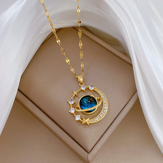 The Infinity Galaxy Necklace, a celestial masterpiece designed to capture the magic of the cosmos. Featuring a luminous deep blue planet orbited by shimmering cubic zirconia stars, this pendant is beautifully framed in a radiant gold-tone setting, perfect for dreamers, stargazers, and lovers of unique jewelry.