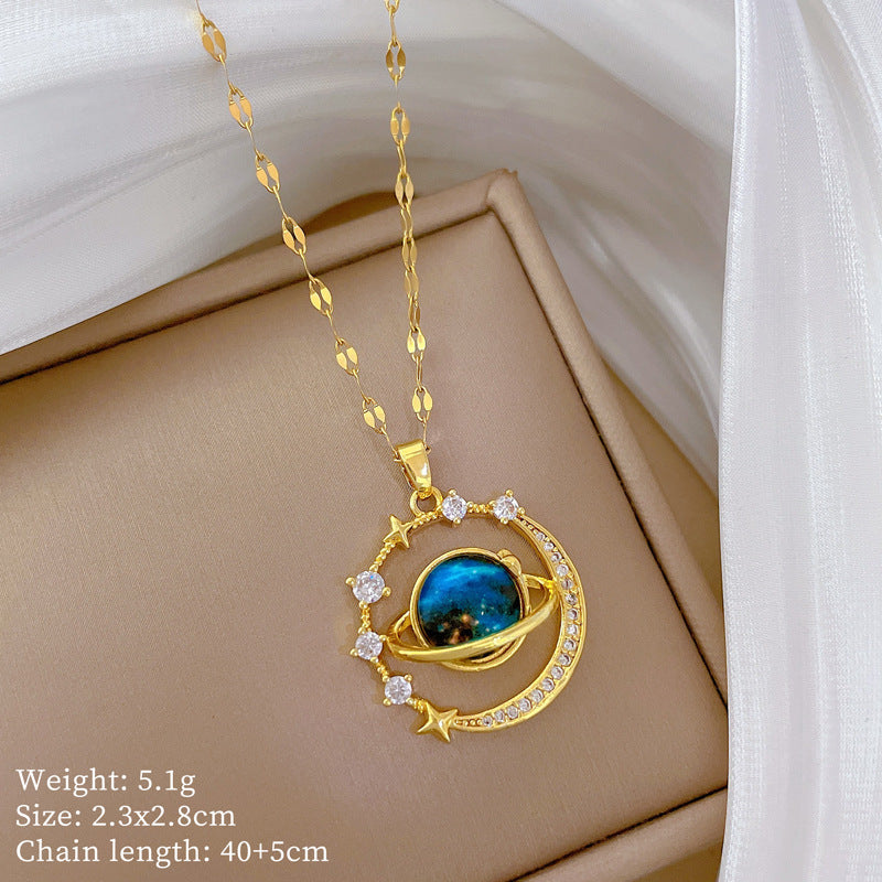 The Infinity Galaxy Necklace, a celestial masterpiece designed to capture the magic of the cosmos. Featuring a luminous deep blue planet orbited by shimmering cubic zirconia stars, this pendant is beautifully framed in a radiant gold-tone setting, perfect for dreamers, stargazers, and lovers of unique jewelry.