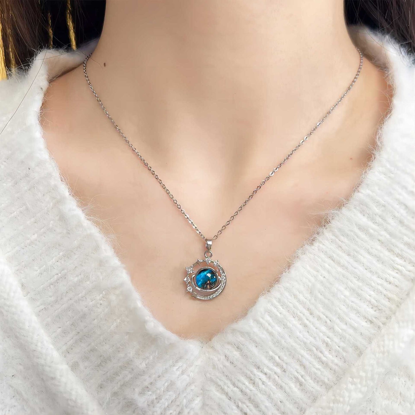 The Infinity Galaxy Necklace, a celestial masterpiece designed to capture the magic of the cosmos. Featuring a luminous deep blue planet orbited by shimmering cubic zirconia stars, this pendant is beautifully framed in a radiant gold-tone setting, perfect for dreamers, stargazers, and lovers of unique jewelry.