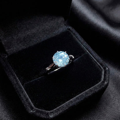 Lunara Ice Ring features a mesmerizing round sea-blue firework-cut stone that catches light from every angle. Set on a sleek silver-tone band, this ring delivers statement sparkle while remaining soft, feminine, and wearable for everyday moments.