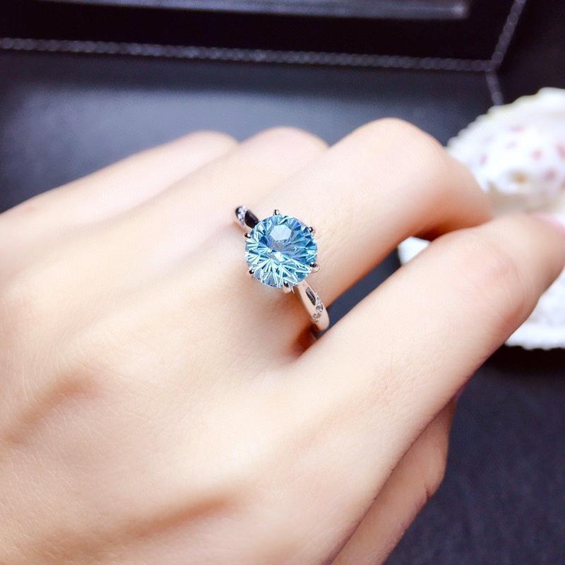 Lunara Ice Ring features a mesmerizing round sea-blue firework-cut stone that catches light from every angle. Set on a sleek silver-tone band, this ring delivers statement sparkle while remaining soft, feminine, and wearable for everyday moments.