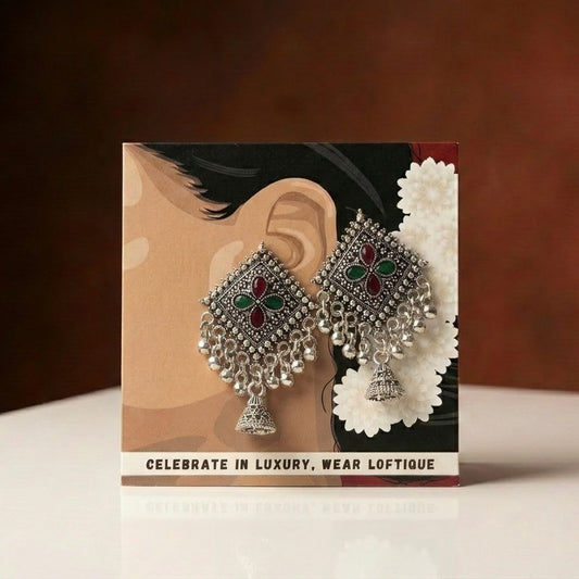 A beautiful expression of heritage elegance, this piece captures the richness of traditional artistry with a vibrant play of color and intricate detailing. The geometric motif adorned with deep-toned accents flows into delicate cascading drops, creating a look that feels festive, graceful, and full of character.