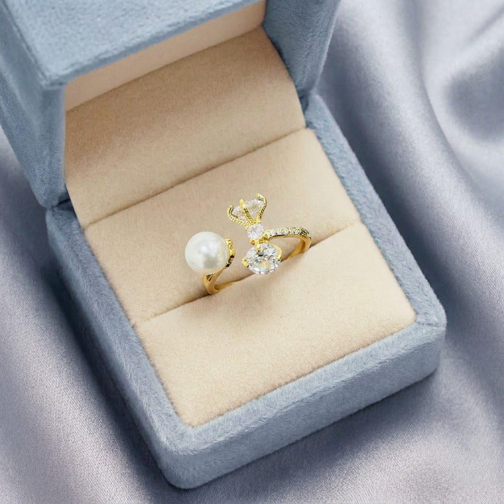 A whimsical blend of pearl elegance and deer-inspired charm, this ring features a luminous pearl paired with a sparkling crystal deer motif. Its open silhouette and delicate antler detailing create a dreamy statement that feels graceful, magical, and beautifully unique.