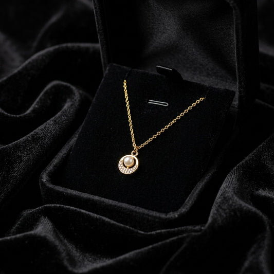A soft pearl glow framed with delicate crystal sparkle, this necklace captures a timeless elegance in the most minimal way. Its refined circular pendant and sleek silver finish create a graceful everyday piece that feels effortlessly luxurious.