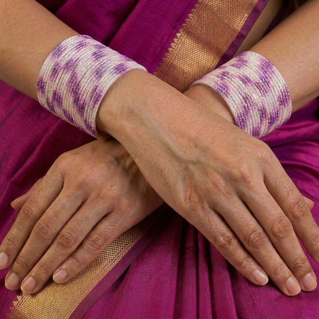 A radiant blend of tradition and celebration, these bangles glow in a vibrant pink hue adorned with delicate golden accents that shimmer beautifully in the light. Their festive sparkle and graceful stacked look bring a joyful charm to every ethnic moment.