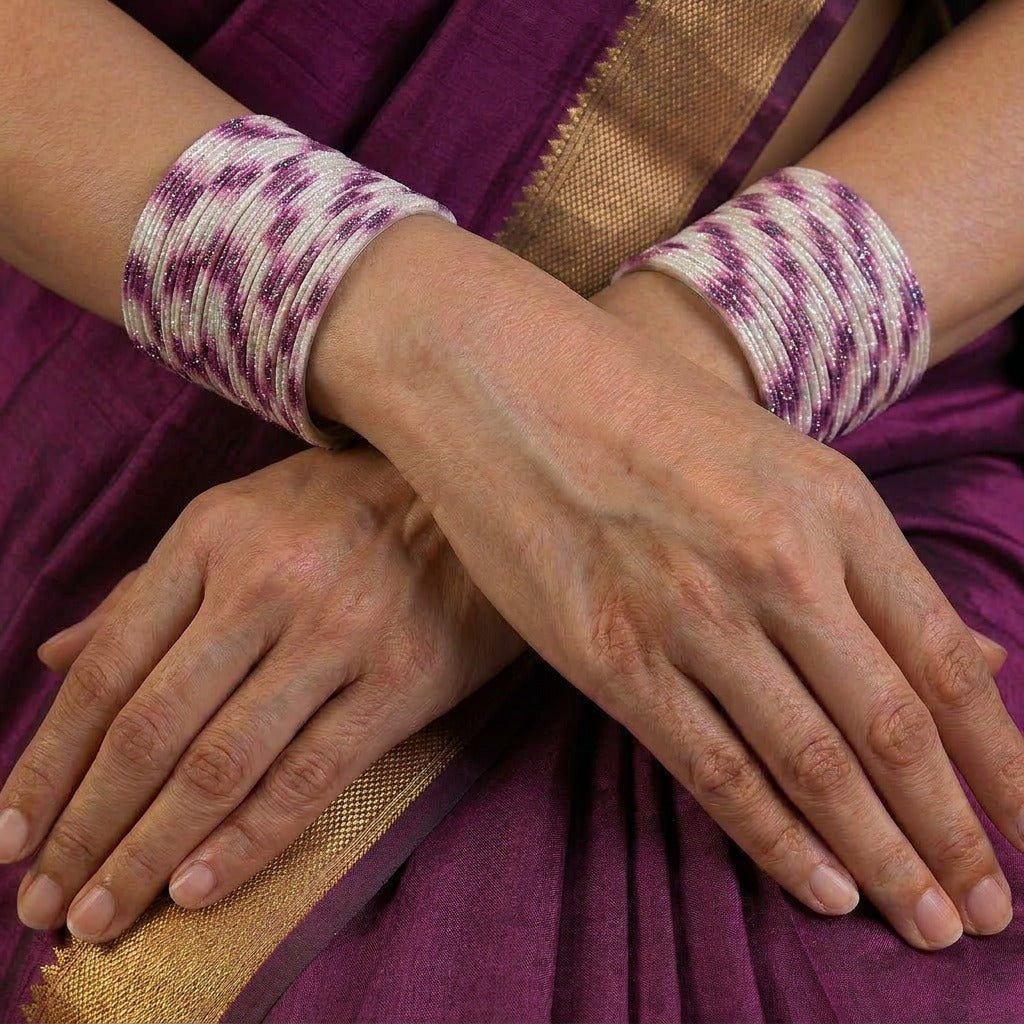 A radiant blend of tradition and celebration, these bangles glow in a vibrant pink hue adorned with delicate golden accents that shimmer beautifully in the light. Their festive sparkle and graceful stacked look bring a joyful charm to every ethnic moment.