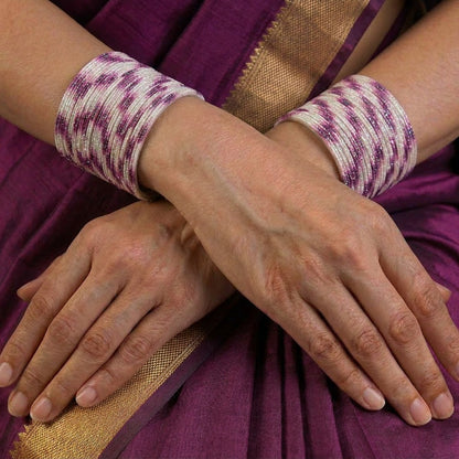 A radiant blend of tradition and celebration, these bangles glow in a vibrant pink hue adorned with delicate golden accents that shimmer beautifully in the light. Their festive sparkle and graceful stacked look bring a joyful charm to every ethnic moment.