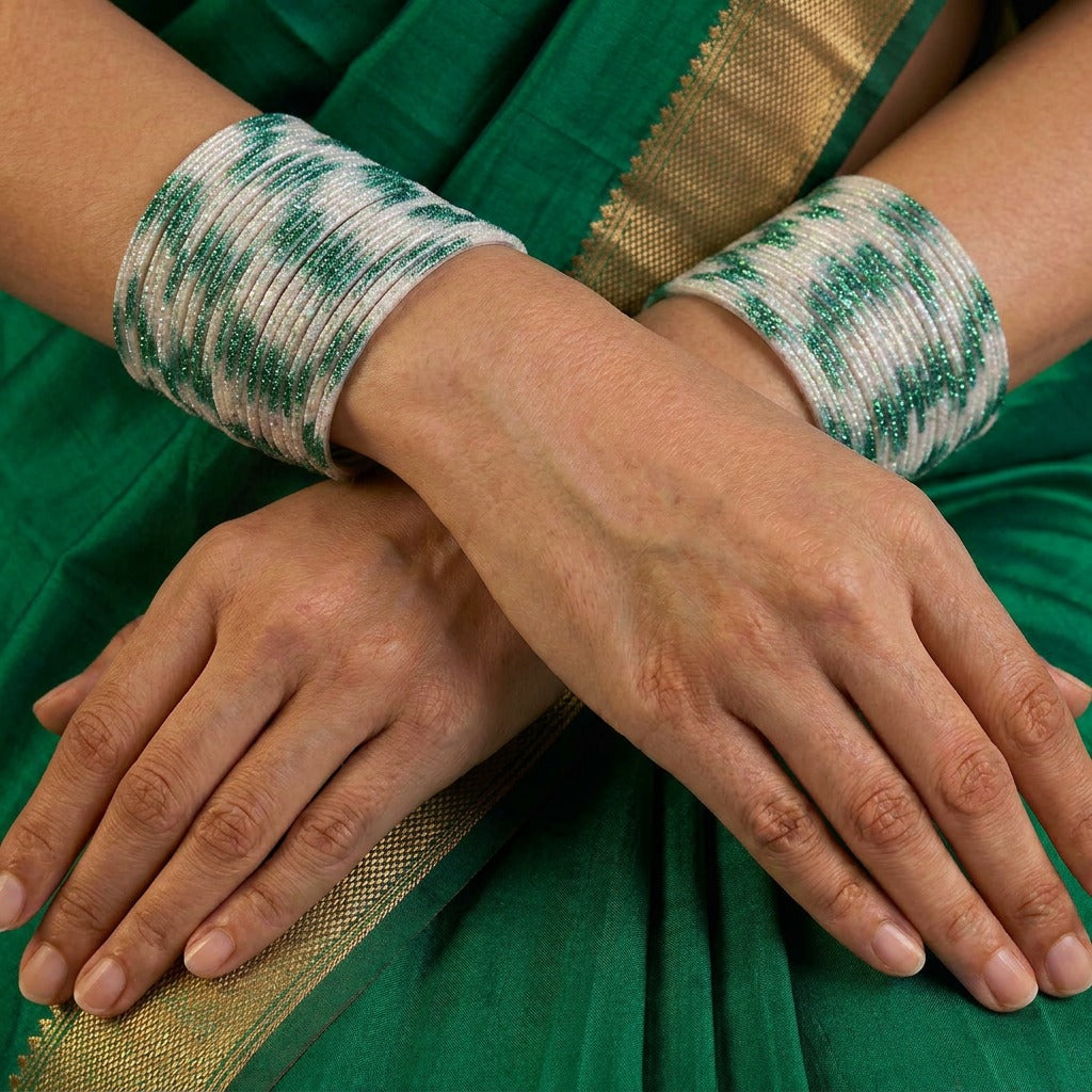 A radiant blend of tradition and celebration, these bangles glow in a vibrant pink hue adorned with delicate golden accents that shimmer beautifully in the light. Their festive sparkle and graceful stacked look bring a joyful charm to every ethnic moment.