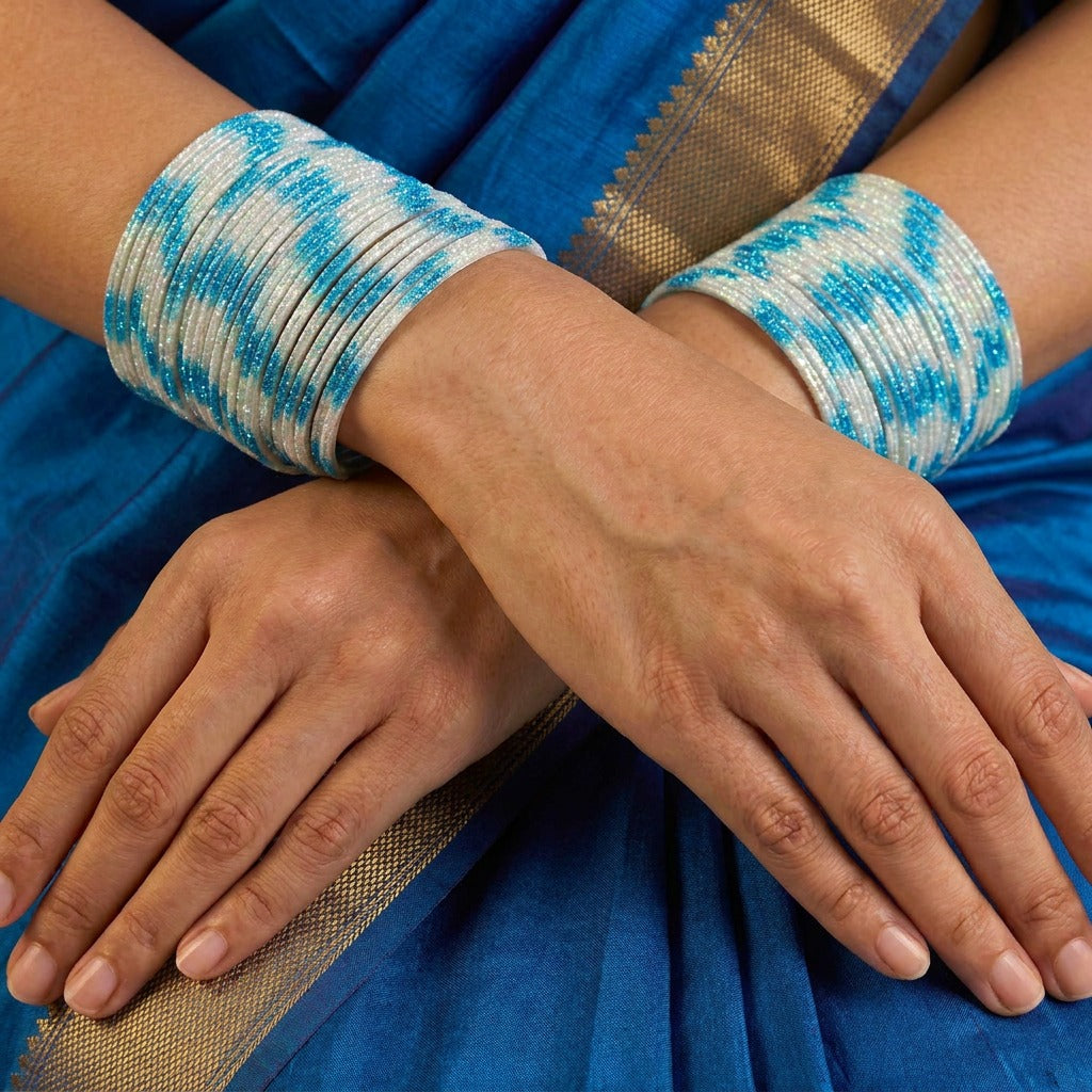 A radiant blend of tradition and celebration, these bangles glow in a vibrant pink hue adorned with delicate golden accents that shimmer beautifully in the light. Their festive sparkle and graceful stacked look bring a joyful charm to every ethnic moment.