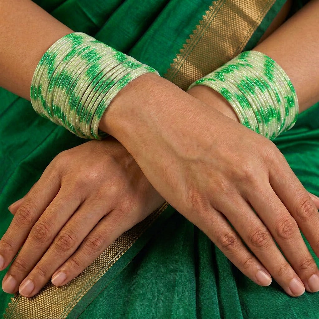 A radiant blend of tradition and celebration, these bangles glow in a vibrant pink hue adorned with delicate golden accents that shimmer beautifully in the light. Their festive sparkle and graceful stacked look bring a joyful charm to every ethnic moment.