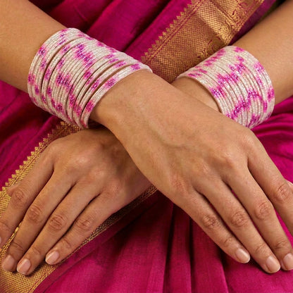 A radiant blend of tradition and celebration, these bangles glow in a vibrant pink hue adorned with delicate golden accents that shimmer beautifully in the light. Their festive sparkle and graceful stacked look bring a joyful charm to every ethnic moment.