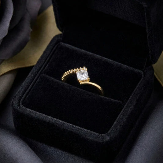 A radiant statement of clean elegance, this ring captures the beauty of modern minimalism with its striking square-cut centerpiece and refined silhouette. The brilliant stone catches light effortlessly, creating a timeless sparkle that feels both luxurious and graceful.