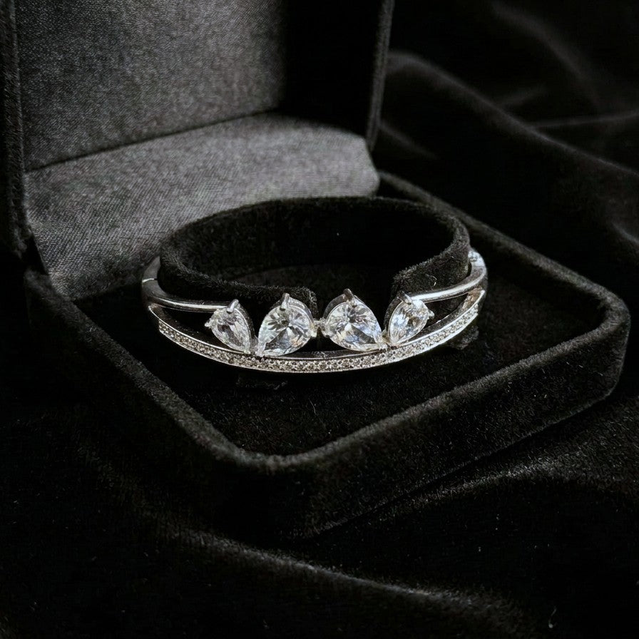 A sleek brilliance that flows with effortless grace, this bracelet captures the beauty of cascading light in a refined, modern form. The line of shimmering crystals paired with delicate drop accents creates a soft, radiant movement that feels both luxurious and timeless.