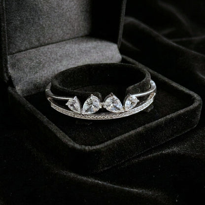 A sleek brilliance that flows with effortless grace, this bracelet captures the beauty of cascading light in a refined, modern form. The line of shimmering crystals paired with delicate drop accents creates a soft, radiant movement that feels both luxurious and timeless.